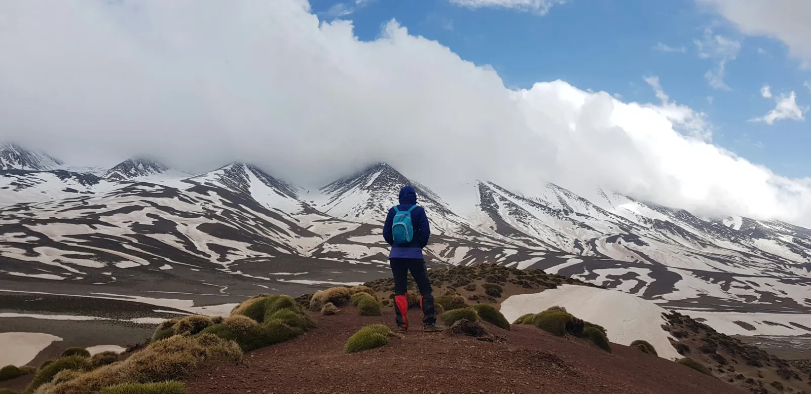 Excursionista frente a las cumbres nevadas del Alto Atlas