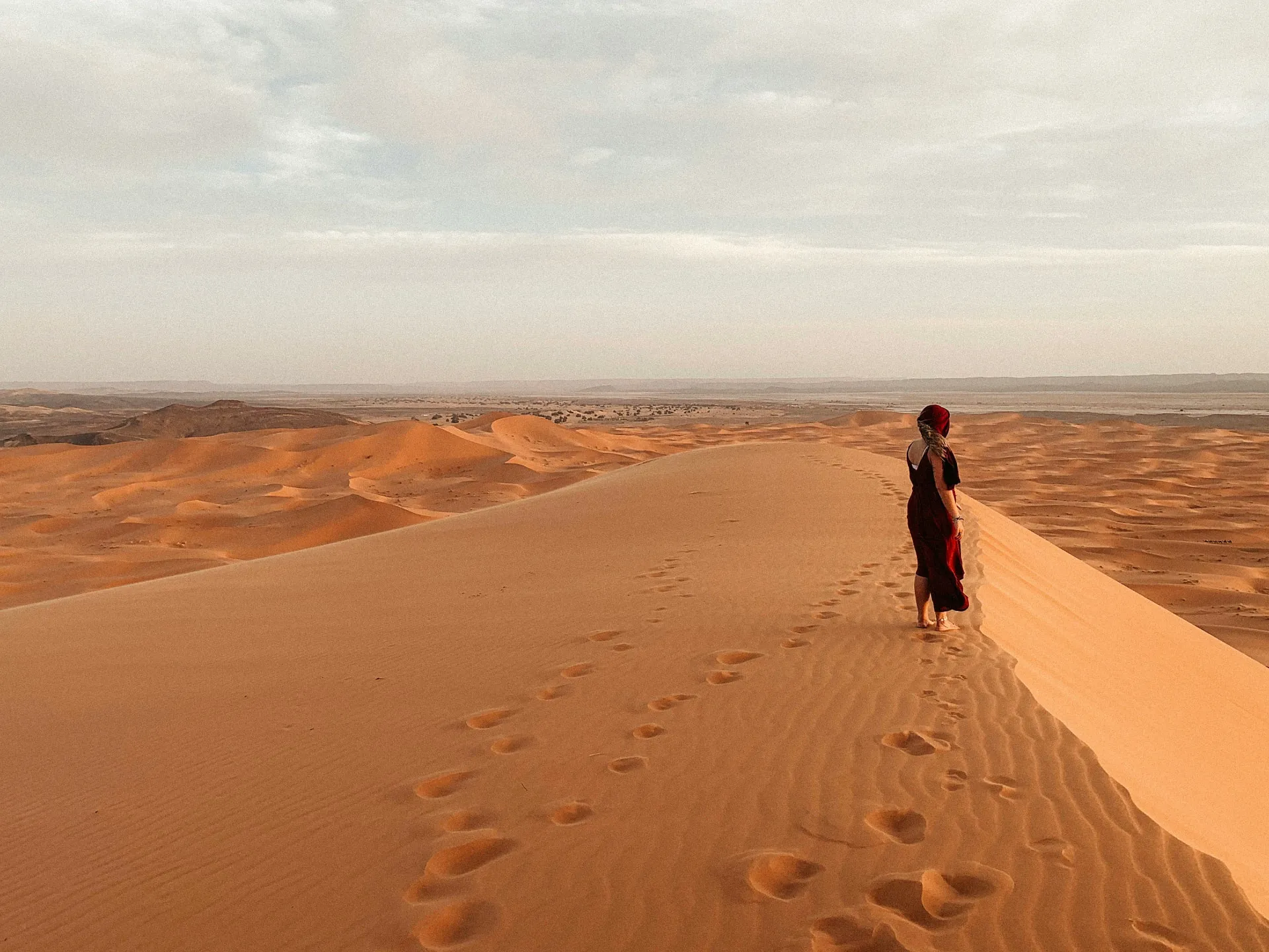 Viajera contemplando las grandes dunas del desierto del Sahara al atardecer